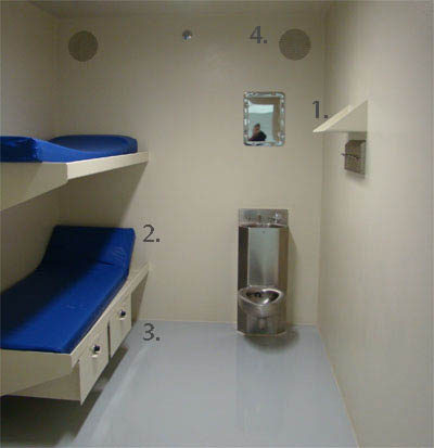 Jail Cell with custom fabricated wall mounted shelf, custom metal wall mounted bunks with under bunk shelfing and custom fabricated cell wall vents